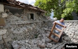 البانیہ میں ایک شخص زلزلے کے بعد اپنے گھر کا ملبہ ہٹا رہا ہے۔ یکم جون 2019