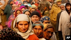Người dân Kashmir xếp hàng đi bỏ phiếu bên ngoài một trạm bỏ phiếu trong giai đoạn bỏ phiếu đầu tiên cho các cuộc bầu cử hội đồng bang Jammu và Kashmir ở Hajan, Ấn Độ, ngày 25/11/2014.