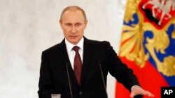 Tổng thống Nga Vladimir Putin phát biểu trước Quốc hội Nga, lên án các nhà lãnh đạo Kyiv đã thay thế ông Yanukovych, và nói rằng họ đã vi phạm quyền của người sắc tộc Nga ở Crimea, ngày 18/3/2014.