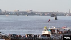 Một chiếc phà chở khách và xe ô tô trên sông Tonle Sap vào ngày đầu tiên của lễ hội nước hàng năm. Chính phủ Campuchia hủy bỏ đua thuyền một lần nữa trong năm nay với lý do mực nước các con sông quá thấp.