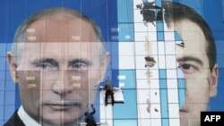 Các công nhân đang gắn tấm quảng cáo, trước bầu cử, hình Tổng thống Nga Medvedev (phải) và Thủ tướng Putin, kêu gọi dân chúng bỏ phiếu cho đảng 'Nước Nga Thống nhất'