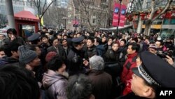 Cảnh sát kêu gọi người dân rời khỏi 1 địa điểm tụ họp trước 1 rạp chiếu phim ở Thượng Hải, Trung Quốc, Chủ Nhật 20/2/2011