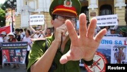 Công an ngăn người dân chụp ảnh một cuộc biểu tình chống Trung Quốc tại Việt Nam. 